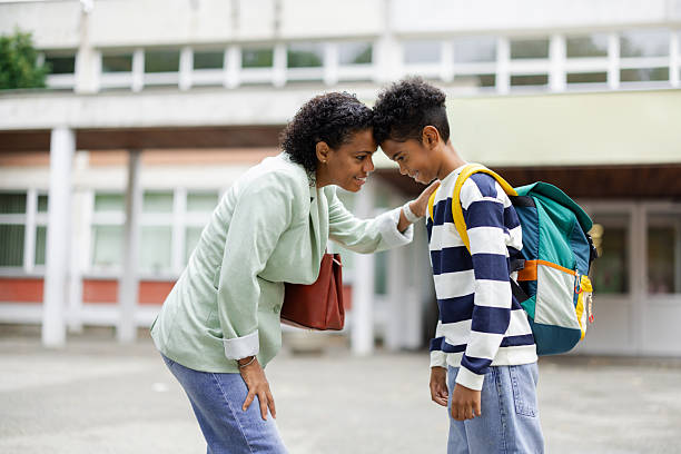 istock Mother encouraging son before school in front of building 2231110866