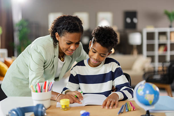 istock Mother helping son with homework at home: homeschooling during the day 2231110921