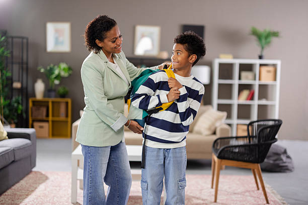 istock Mother helping son getting ready for school in living room 2231110926
