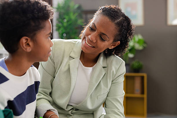 Therapist smiling and listening to young patient during therapy session