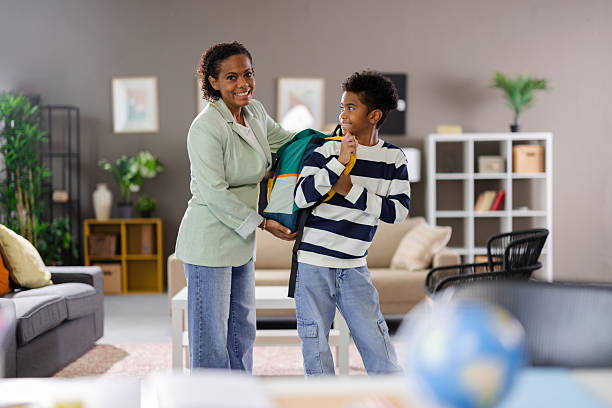istock Mother helping son getting ready for school in living room 2231111112