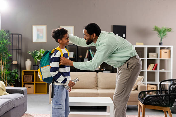 istock Caring father adjusting backpack of son before school 2231111175