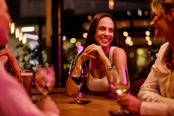 istock Smiling Woman Sharing Drinks and Laughs with Friends in Relaxed Setting 2231112767