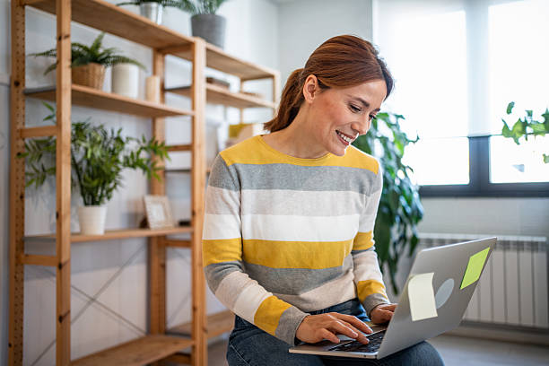 istock Freelancer working from home on her laptop and smiling 2231116419