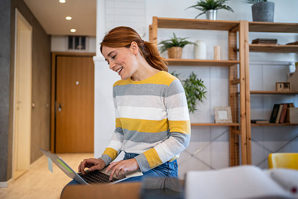 istock Young woman working from home on laptop and smiling 2231116806