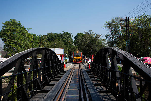 Classic bogie locomotive train on track railway waiting for send receive thai people and foreign travelers passenger journey go to travel visit Kwai river on December 26, 2024 in Kanchanaburi Thailand