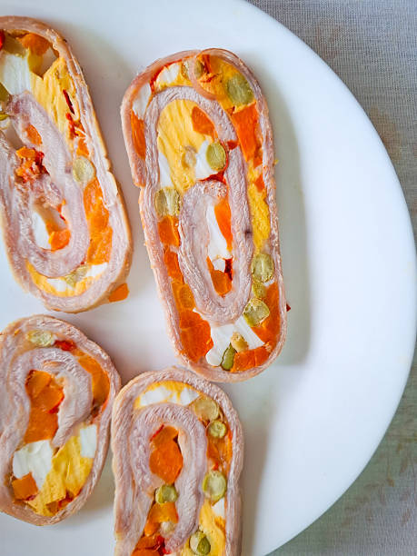 Rolled meet and vegetables on white plate