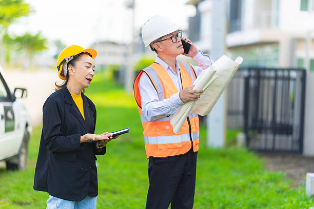 istock Female architect or engineer with blueprints at construction site, teamwork discussion, Caucasian female civil engineer checks progress of housing project with investors. 2231120605
