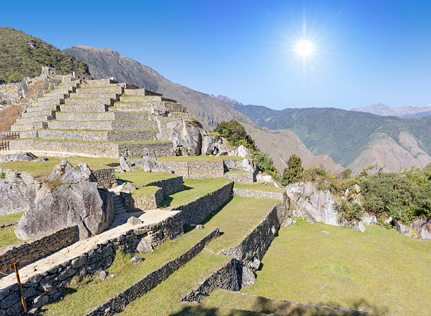 Archaeological site of Machu Picchu in Peru at daylight.\nMachu Picchu is a 15th-century Inca citadel located in the Eastern Cordillera of southern Peru on a mountain ridge at 2,430 meters. It is situated in the Machupicchu District of Urubamba Province about 80 km northwest of Cusco, above the Sacred Valley and along the Urubamba River, which forms a deep canyon with a subtropical mountain climate.