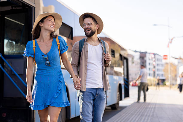 istock Couple joyfully walking hand in hand toward an open bus door 2231121955