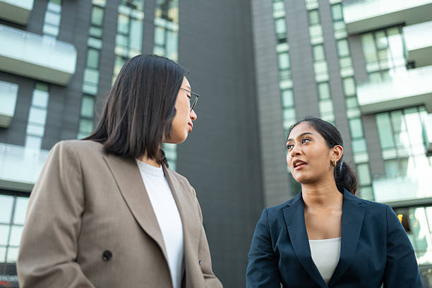 istock Two businesswomen talking outside office building 2231123190