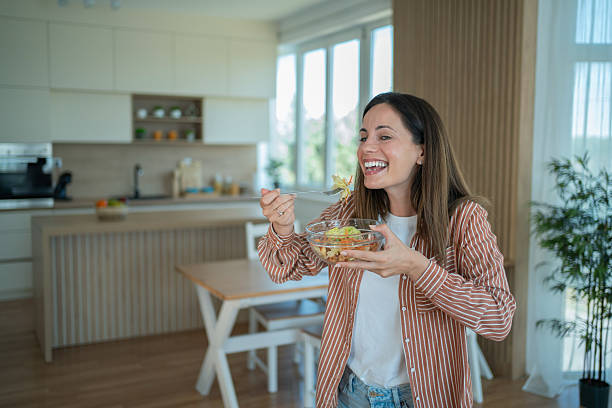 istock Happy woman enjoying fresh salad in modern kitchen 2231125672