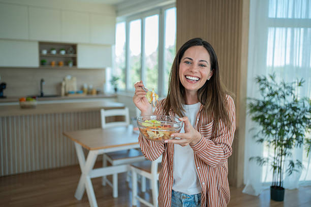 istock Young woman enjoying fresh salad in modern kitchen 2231125687