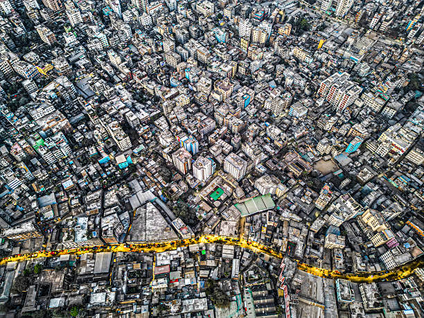 The aerial view of Dhaka shows a densely packed city with narrow streets, blending modern and traditional buildings, reflecting rapid growth and vibrant energy. However, this density causes severe issues like inadequate infrastructure, pollution, and traffic congestion. Overpopulation strains resources such as water, sanitation, and healthcare, making daily life difficult. These challenges contribute to Dhaka’s reputation as an uninhabitable city, highlighting the urgent need for sustainable urban development