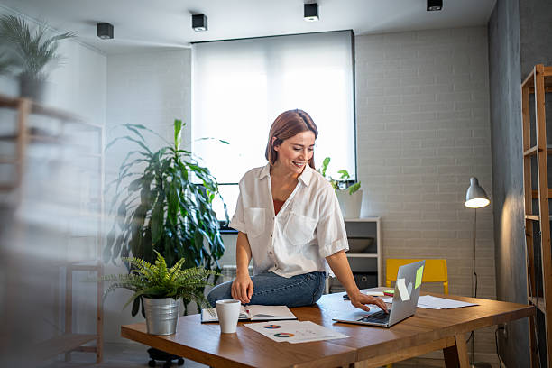 istock Smiling businesswoman working from home using laptop and notebook 2231129714