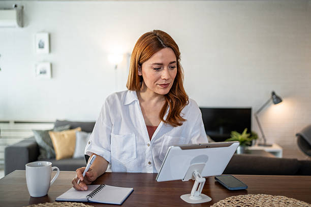 istock Focused businesswoman taking notes while working remotely from home 2231133930