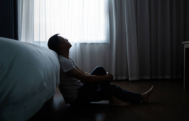 istock Depressed man sitting on bedroom floor 2231134919