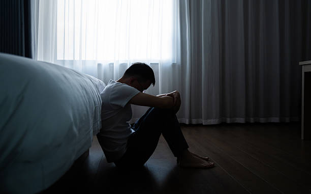 istock Depressed man sitting on bedroom floor 2231134958