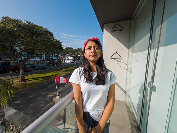 Teen facing the camera on a city balcony, casual pose in bright daylight