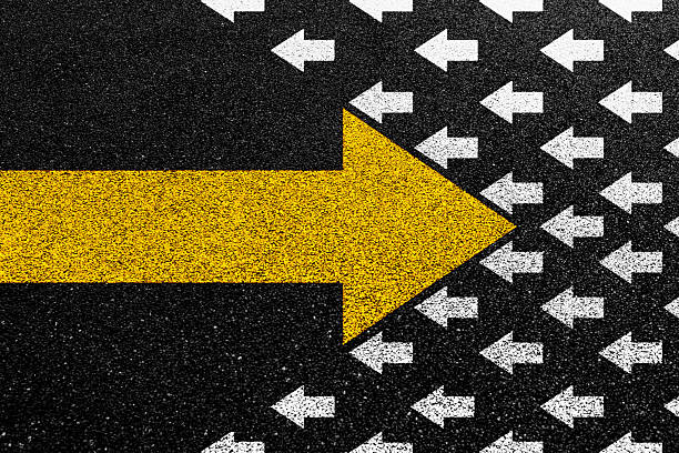 istock Big yellow arrow opposite direction with white arrows on asphalt road 2231135561