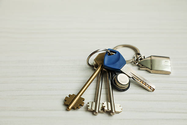 istock Bundle of shiny metal keys arranged on a light wooden table, symbolizing security, property access, home ownership, and real estate. 2231136038