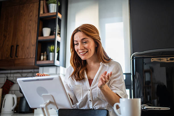 istock Young woman working from home having a video call in her kitchen 2231136071