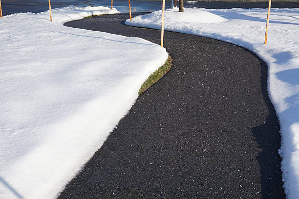 istock Winding pedestrian sidewalk with snow removed after winter snow 2231139403
