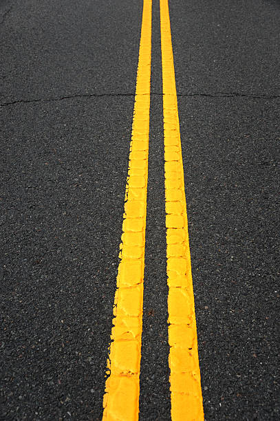 istock double yellow lines on new paved asphalt road surface 2231139489