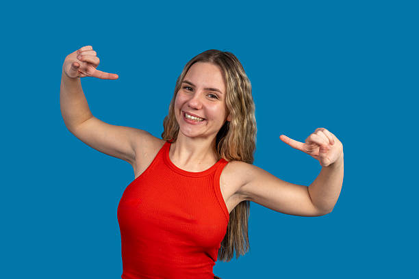 istock Young woman pointing to empty space on blue background 2231140225