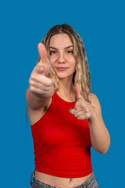 istock Young woman pointing fingers on blue background 2231140365