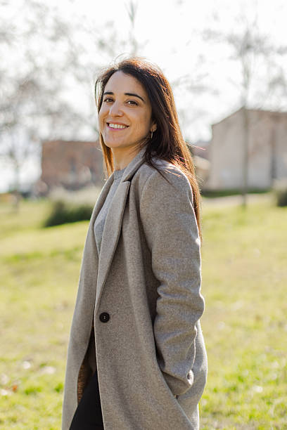 istock Smiling woman looking over her shoulder in a sunlit park 2231140801