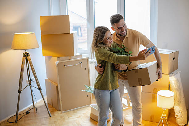 istock Happy couple unpacking boxes in their new home while taking a selfie 2231142227