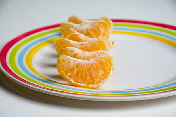 Tangerine slices on a plate isolated on a white background.
