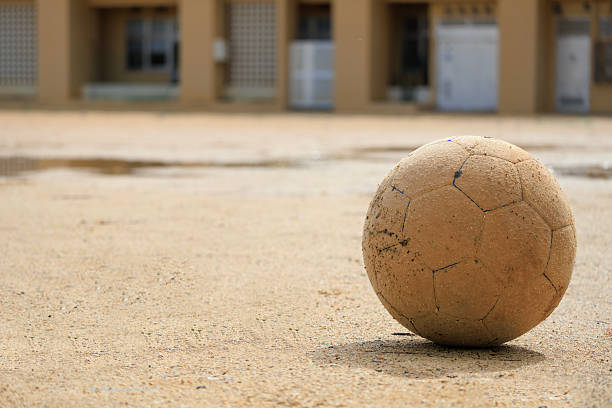 A soccer ball left on a playground after the rain