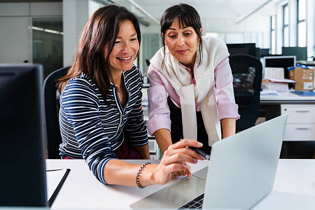 istock Businesswomen collaborating on laptop in modern office 2231145246