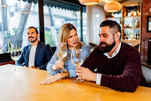 istock Coworkers talking and drinking wine at restaurant 2231146262