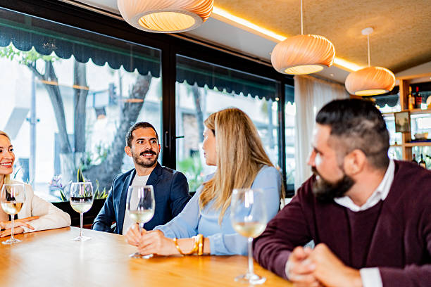 istock Coworkers talking and drinking wine at restaurant 2231146263