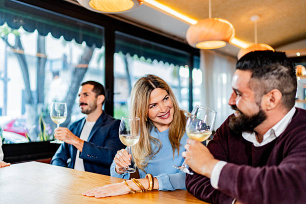istock Coworkers talking and drinking wine at restaurant 2231146265