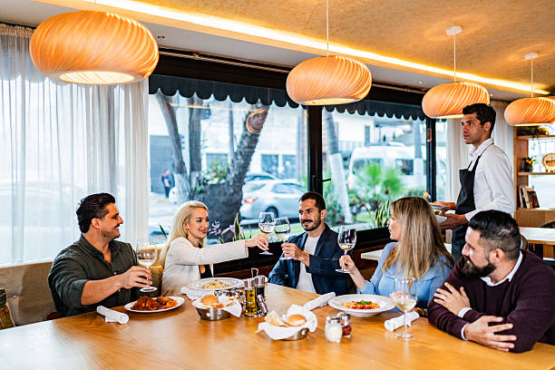 istock Waiter serving food to customers at restaurant 2231146288