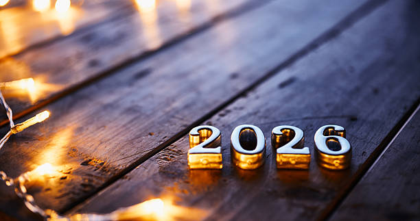 istock Reflective Gold 2026 Numbers with Warm Fairy Lights on Rustic Wood Surface 2231147503