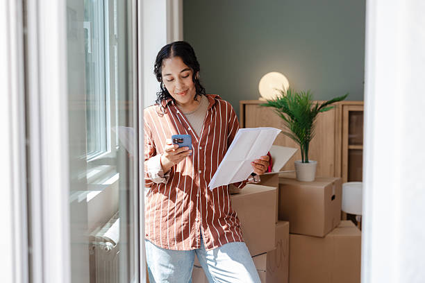 istock Woman using her smartphone while organizing a move into a new apartment 2231151265