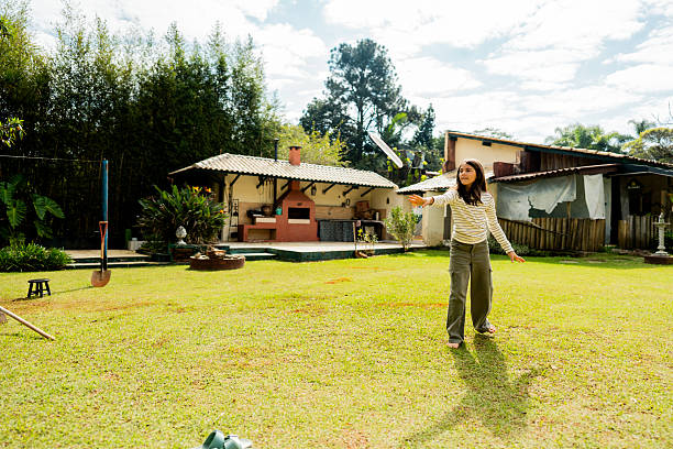 Girl playing throwing plastic disc in the backyard at home
