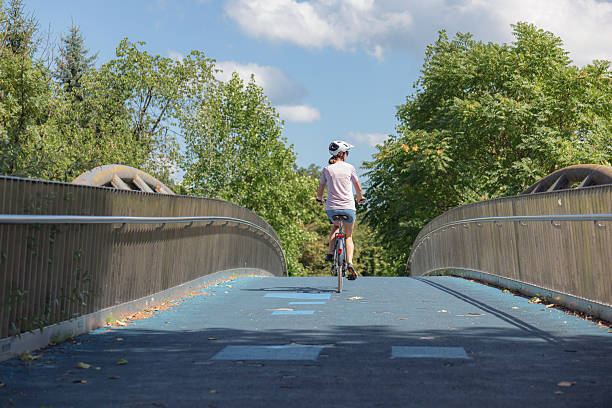 istock Cyclist rides across a modern pedestrian bridge 2231159266