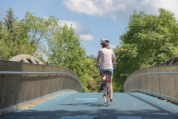 istock Bicyclist crossing a modern bridge on a sunny day 2231159292