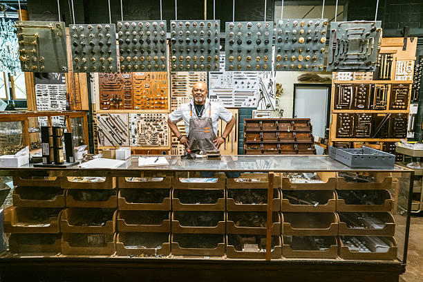 Hardware store owner portrait behind large display of doorknobs and handles