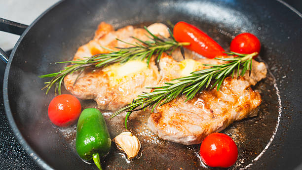 istock Pork Chops in Pan with Cherry Tomatoes, Peppers, and Rosemary 2231165709