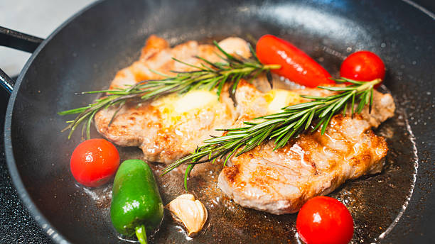 istock Pork Chops in Pan with Cherry Tomatoes, Peppers, and Rosemary 2231165710