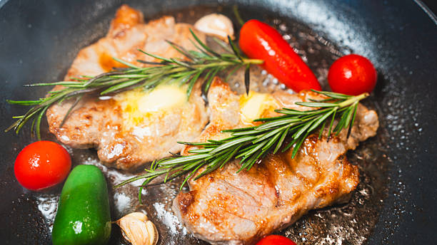 istock Pork Chops in Pan with Cherry Tomatoes, Peppers, and Rosemary 2231165713