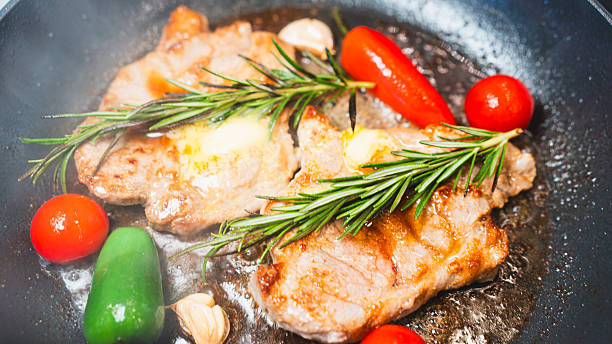istock Pork Chops in Pan with Cherry Tomatoes, Peppers, and Rosemary 2231165714