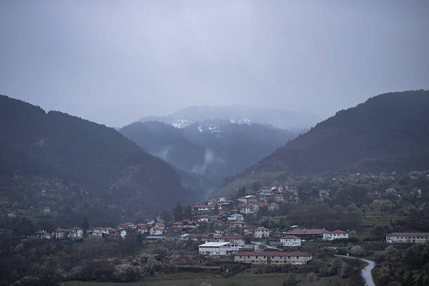 istock Misty Mountain Village Nestled Between Forested Hills 2231166182
